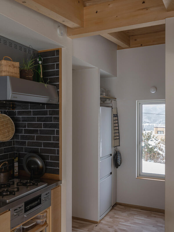 キッチン横には、冷蔵庫置き場や造作の棚やカウンターを設けたパントリーをレイアウト。カウンター下は今、愛犬用スペースとして使われている