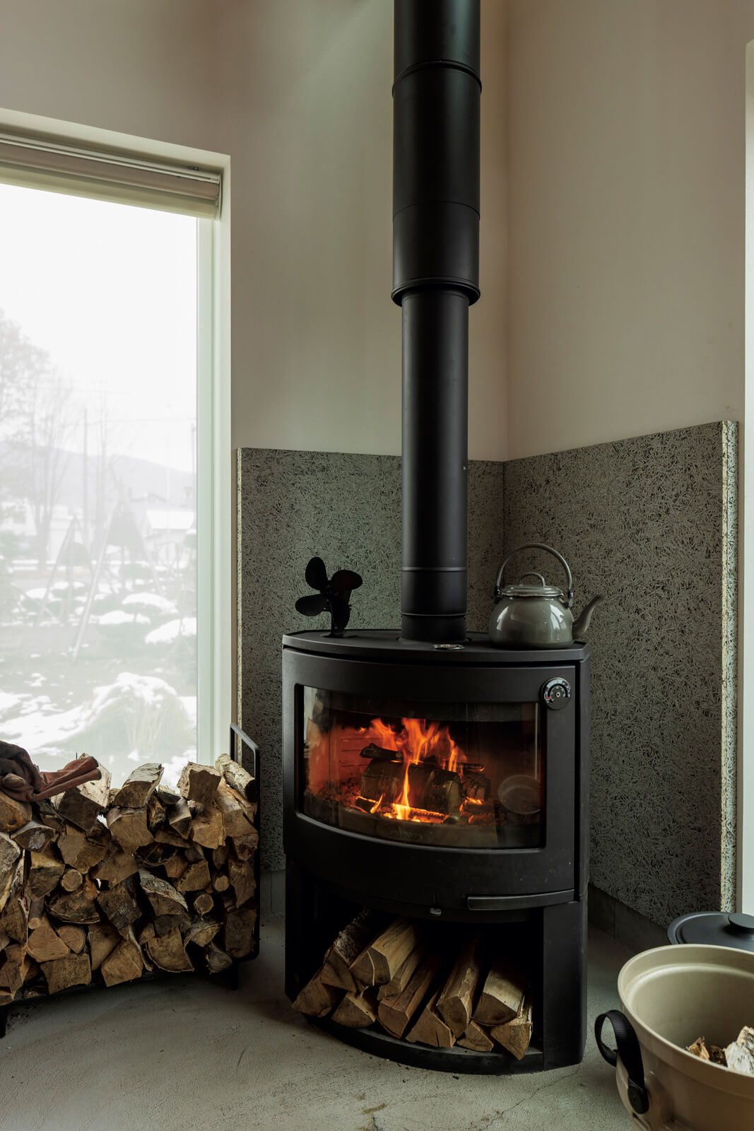 リビングのコンクリート土間には、Sさんが選んだフランス製の薪ストーブ「INVICTA（アンヴィクタ）」を設置。炉壁には木毛セメント板を採用。薪火でシチューやあんこを炊くのが冬の楽しみに
