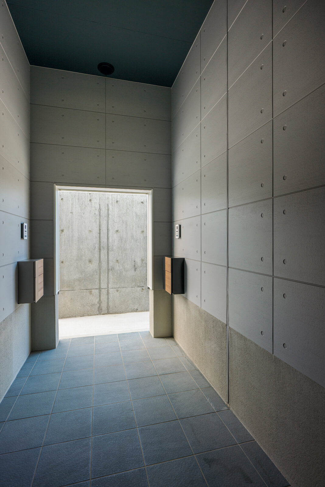 3mほど建物の中に引き込まれた共用の玄関ポーチ。中が見えないよう、入り口の前に目隠しの壁を設置した