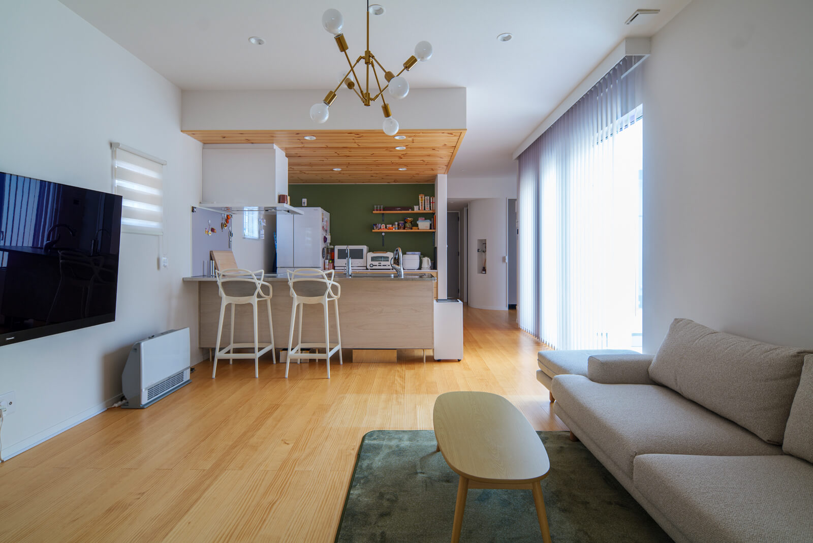 床に無垢パイン材を採用したご家族用のLDK。約16帖で中庭に向けて開けているので開放的