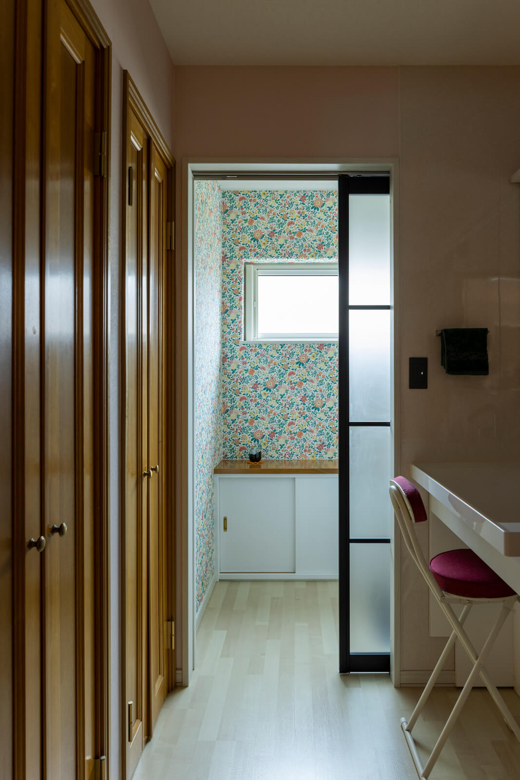 既存の位置を変えずに設備と内装を一新したお母さんの水まわり。収納扉は既存の木製建具を再利用した。右手奥には親子世帯共用の浴室がある