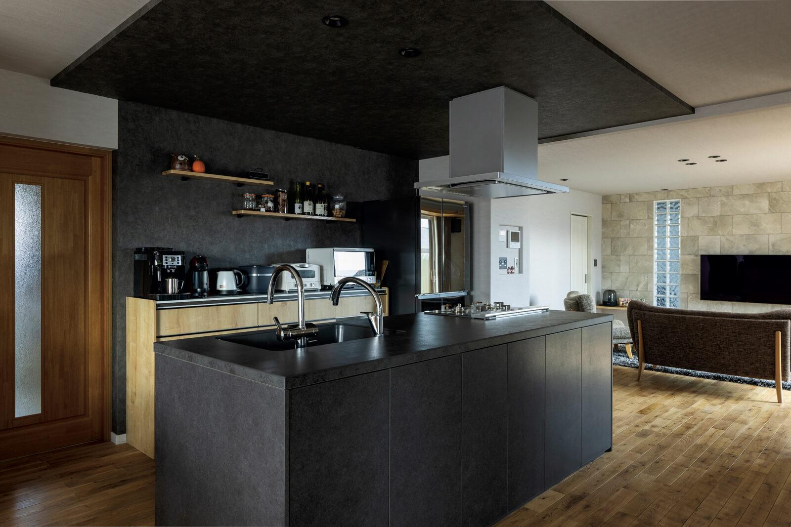 ワイン好きなWさんの「非日常感を味わえる家にしたい」という要望に応え、ダークな色調で整えたキッチン。大きなワインセラーも備えて、家飲みが楽しい住まいに