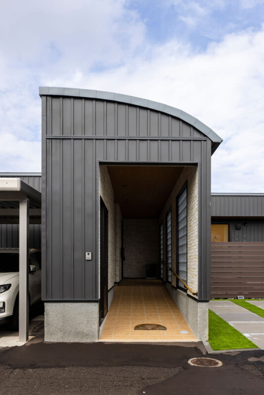 スロープにしたアプローチは屋根と壁に守られていて、安心感を持って移動できる