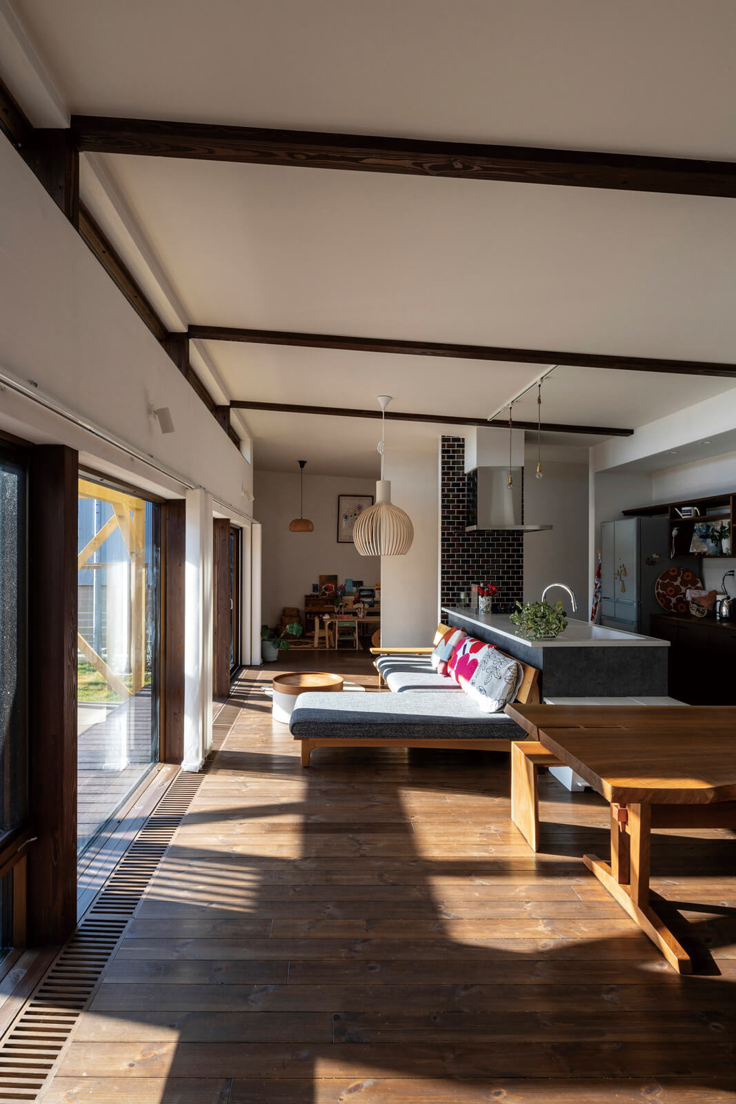 LDKにはダイナミックな大開口と3mの屋根なり天井を設え、抜け感を演出。こげ茶に着色した現しの構造梁が開放的な空間を引き締める