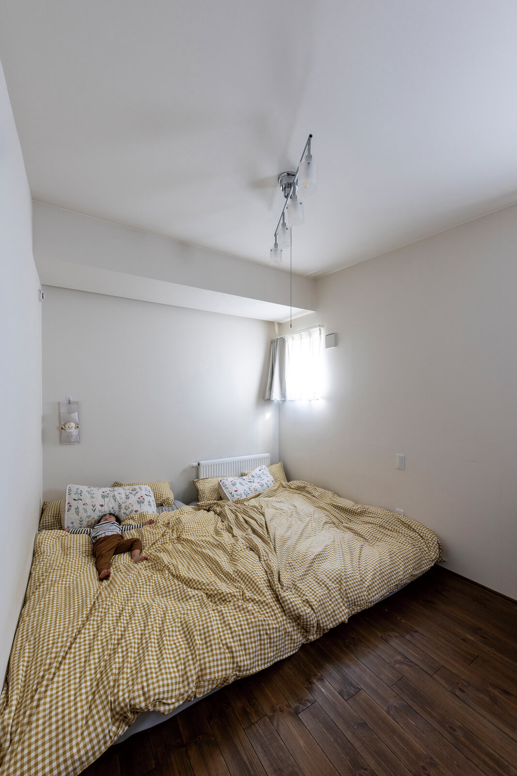 ゲストルームの隣に位置する寝室。白とこげ茶を基調にシンプルな空間に仕上げた