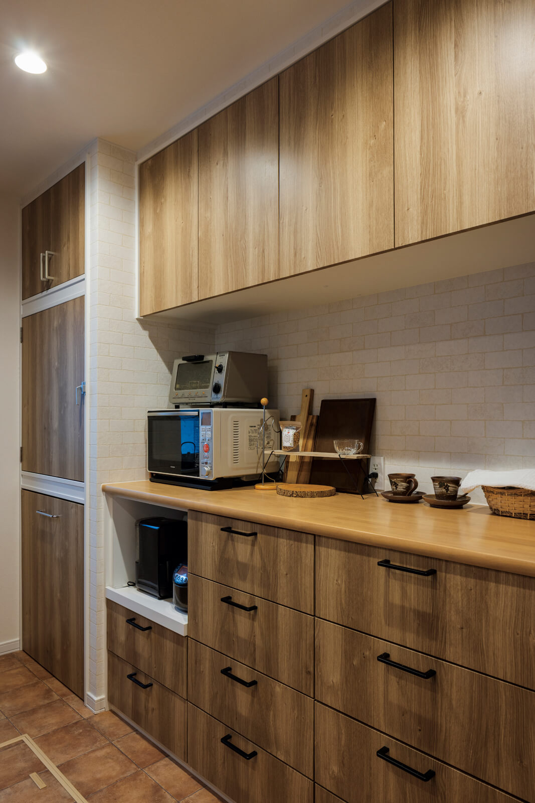 対面式キッチンの背面には、奥さんの使い勝手に合わせた収納を造作。新濱建設の提案で、外気導入式食品庫と大型ごみ置き場も設えた