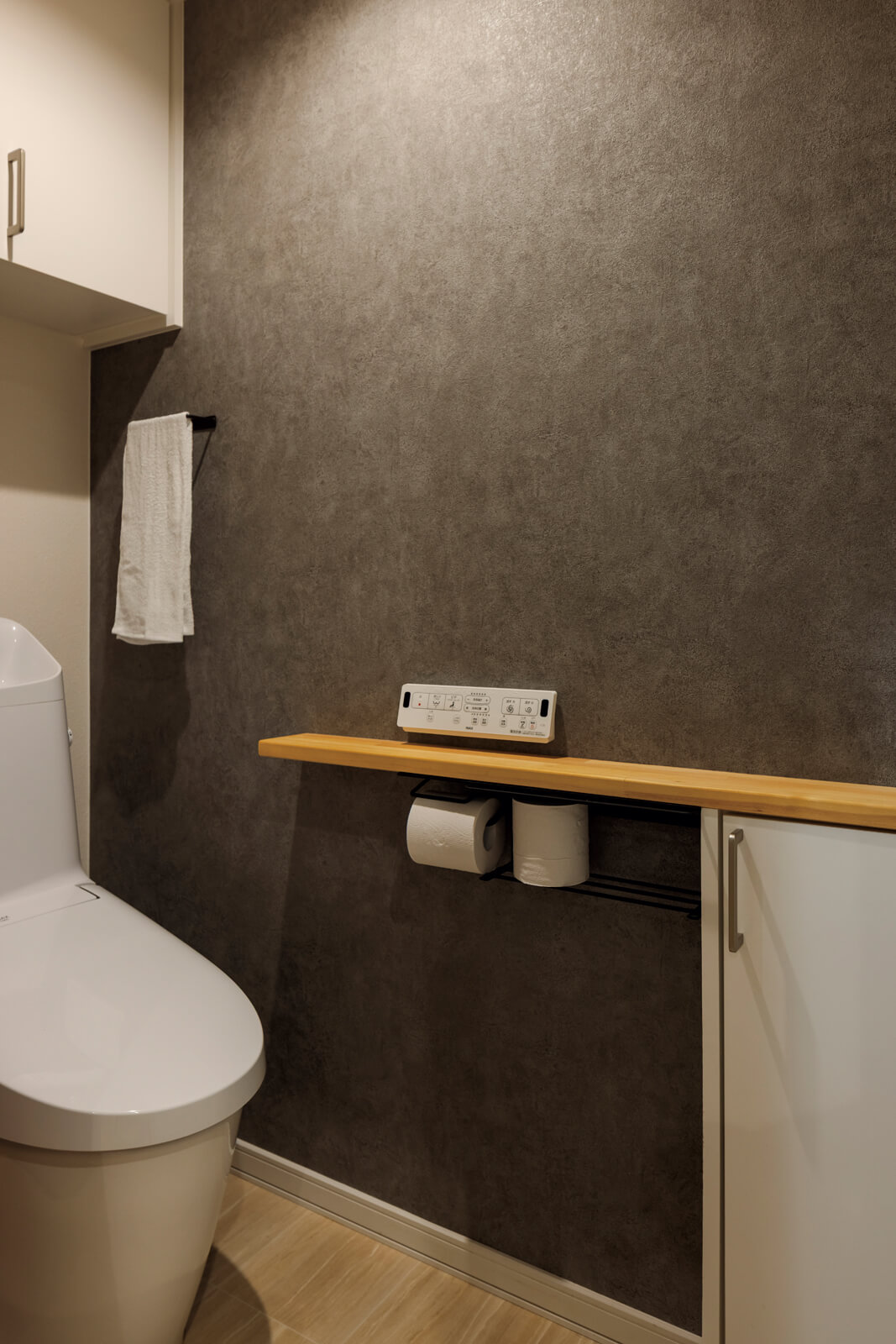 造作収納、カウンターを設え、ダークグレイのアクセントクロスを用いたトイレは「空間としての完成度が高い」と、奥さんのお気に入り