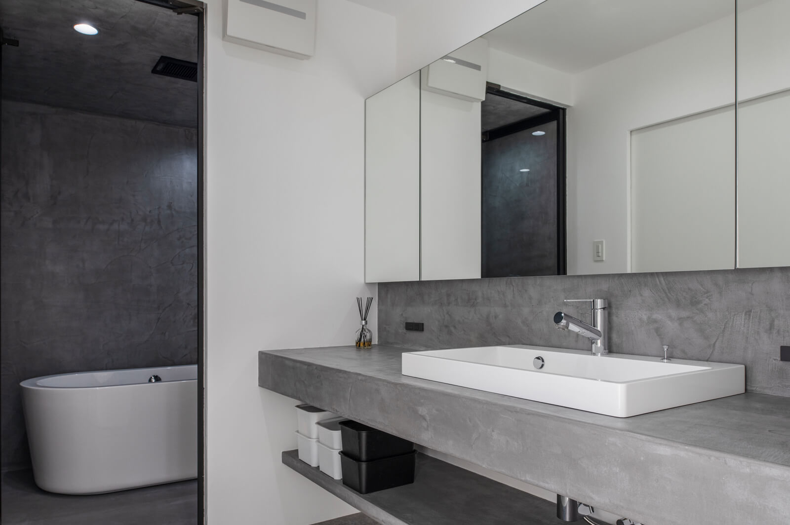 奥さんが細部までこだわった浴室と洗面台。ここにもモールテックスを採用し、アーバンな雰囲気に仕上げている