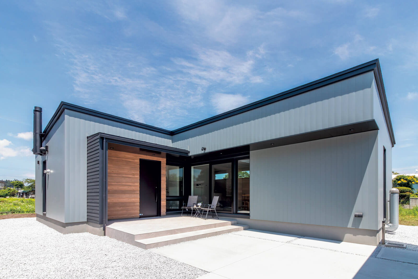 ガルバリウム鋼板に、木目調の窯業系サイディングでアクセントを添えたスタイリッシュな外観。椅子とテーブルを置くとテラスとしても利用できる玄関ポーチは約9帖で、リビングの窓からアクセスできる