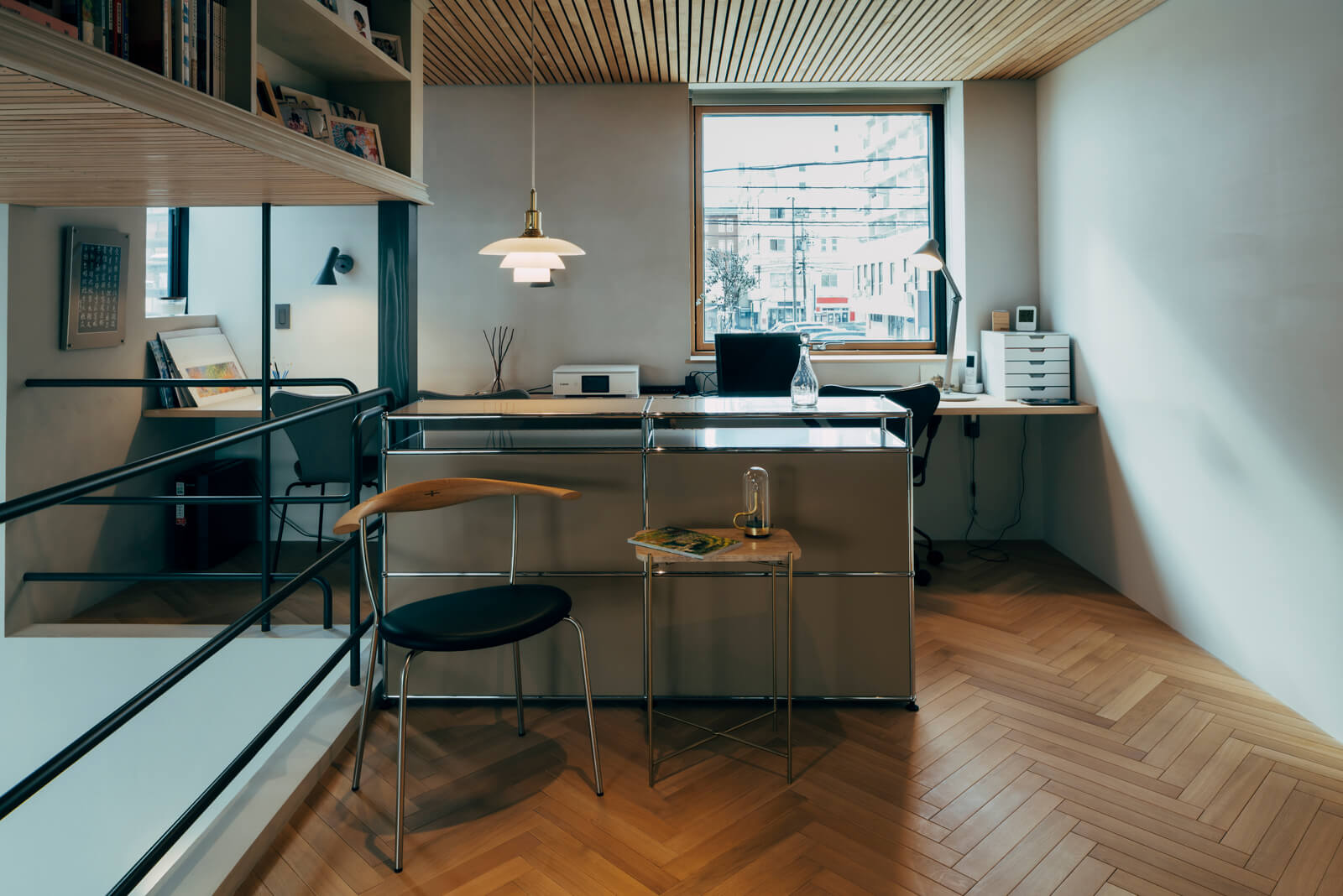 吹き抜けと面している奥さんのワークスペース兼趣味室は約11帖の広さ。収納ボードを間仕切りとして利用し、手前と窓際をさりげなくゾーニングした。天井高は2.2ｍと通常より20㎝ほど低くなっており、落ち着きのある雰囲気