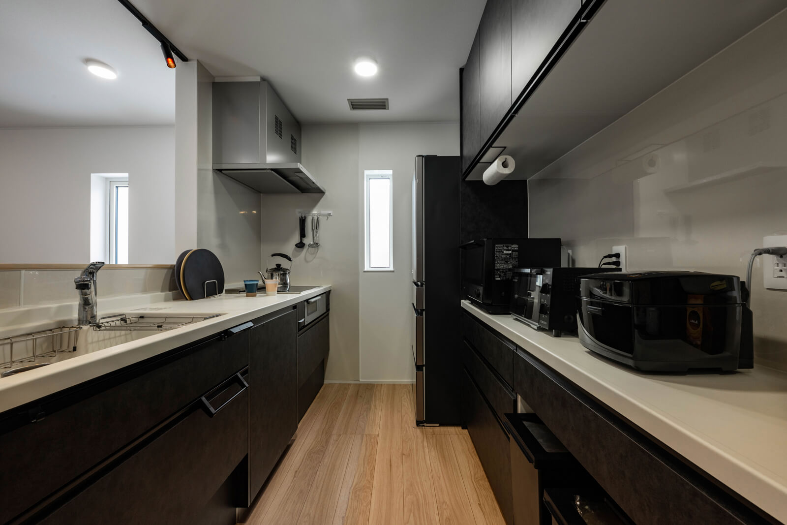 黒を基調としたシックな雰囲気のキッチン。通路の幅が1.2ｍほどあるので、大人二人が同時に作業をしても余裕がある