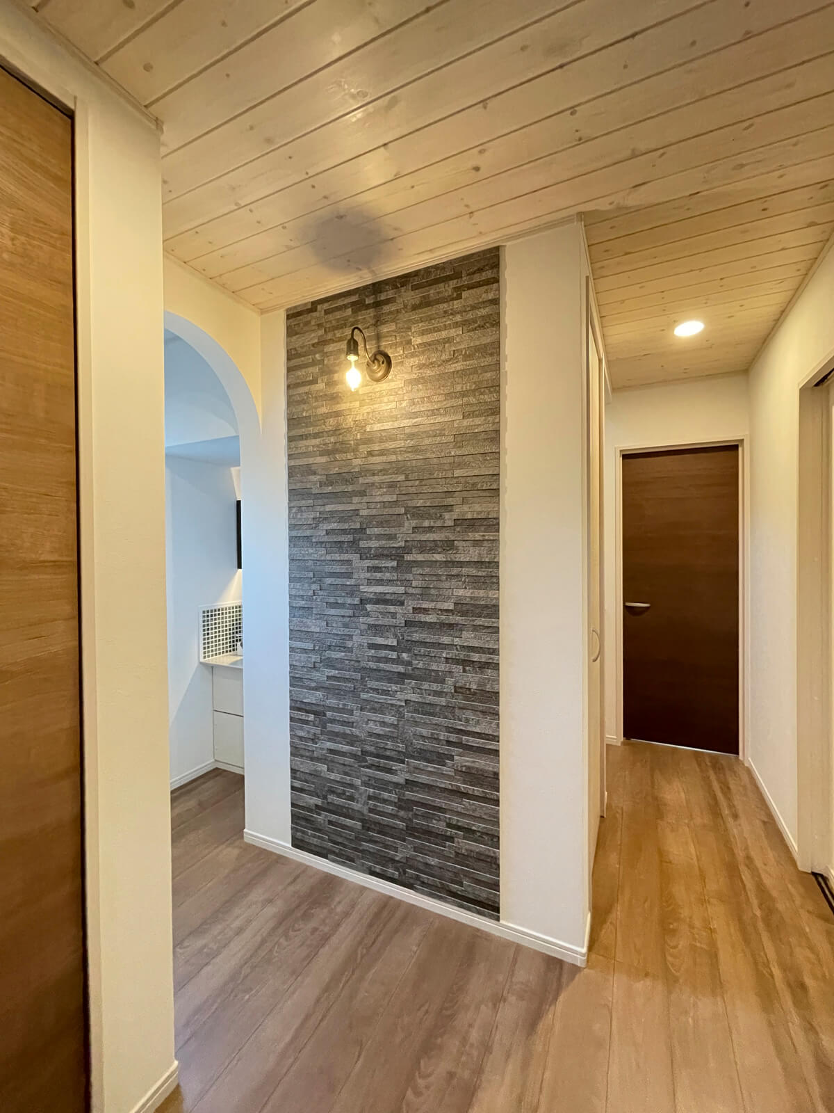 帰宅してすぐに手が洗えるように、玄関の近くに洗面台を配置。アクセントウォールやアールの下がり壁が意匠性を高めている