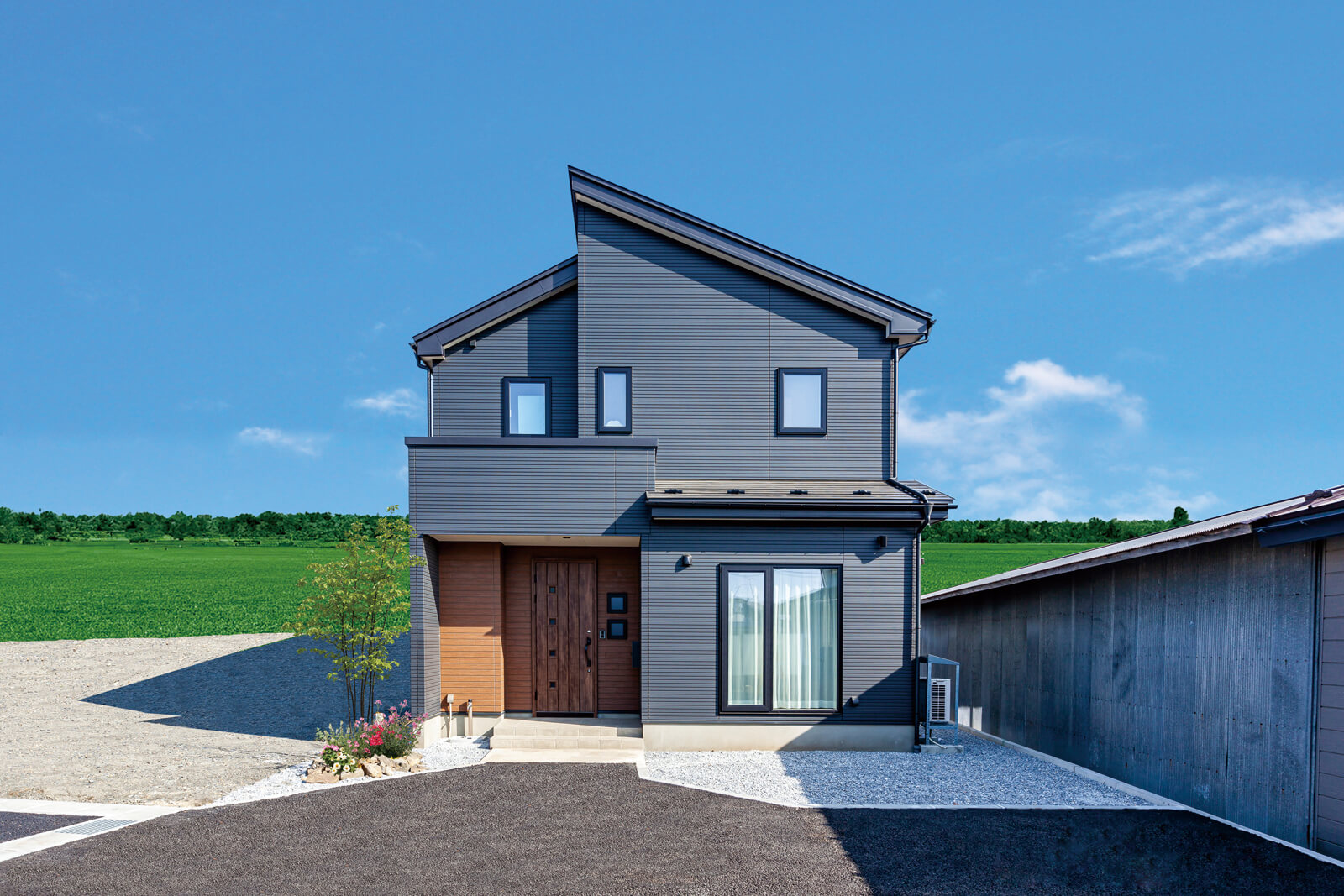 段違い屋根が印象的なフォルムの外観。リビングの大開口からも外に出ることができる