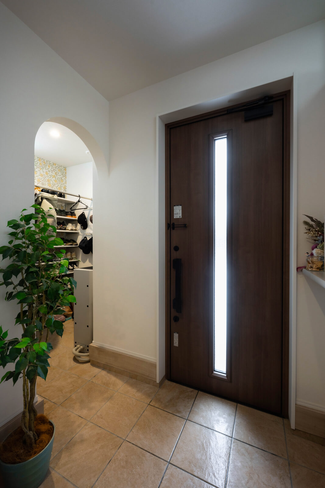 玄関に隣接してシューズクロークを設えた。アールの垂れ壁がかわいい印象を醸す