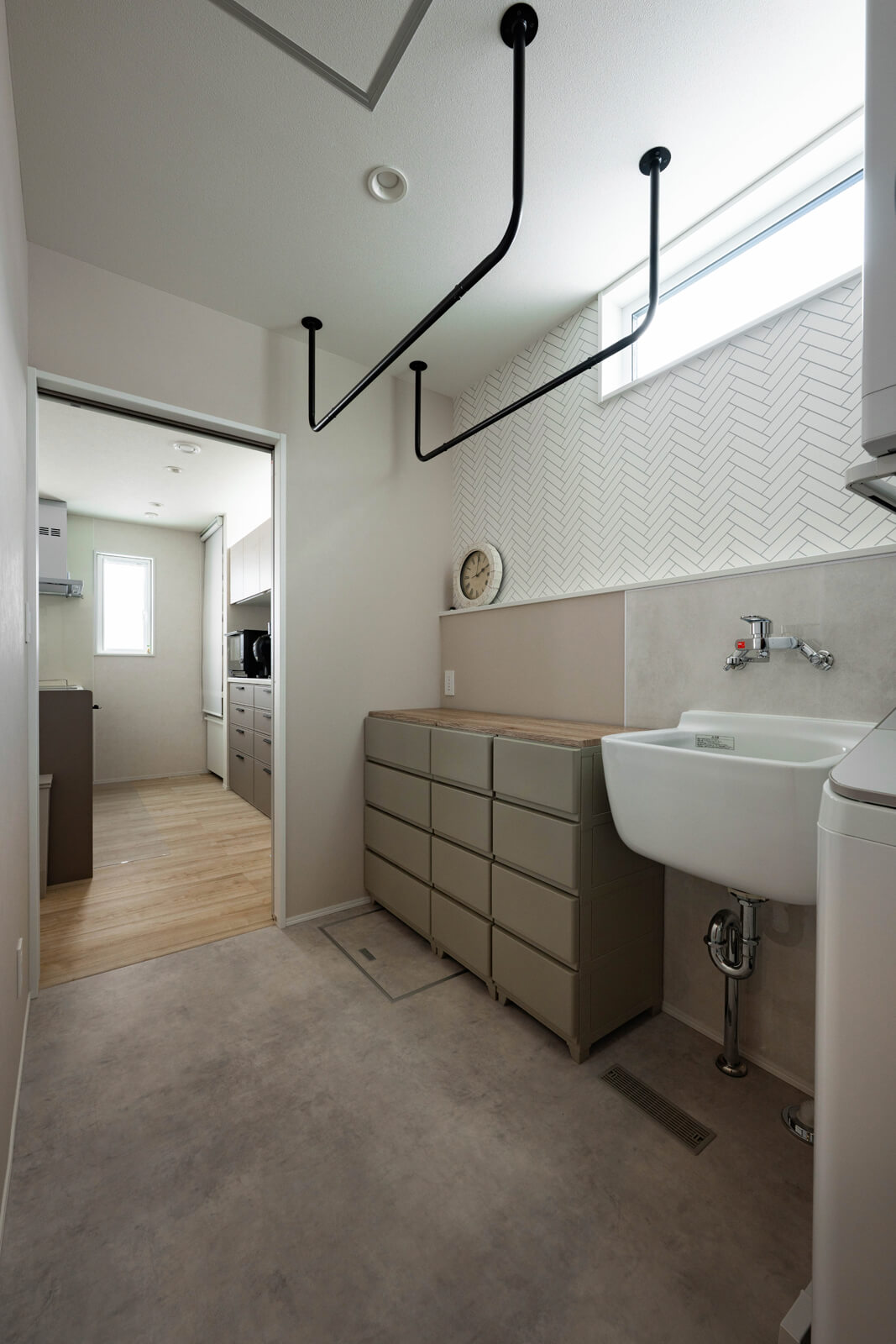 キッチンの隣に配置されたランドリールーム兼脱衣室。洗濯・乾燥・収納を1ヵ所に集約させた家事ラク動線を実現している。汚れ物を予洗いできるスロップシンクは、身長の高い奥さんの使いやすい95㎝の高さ