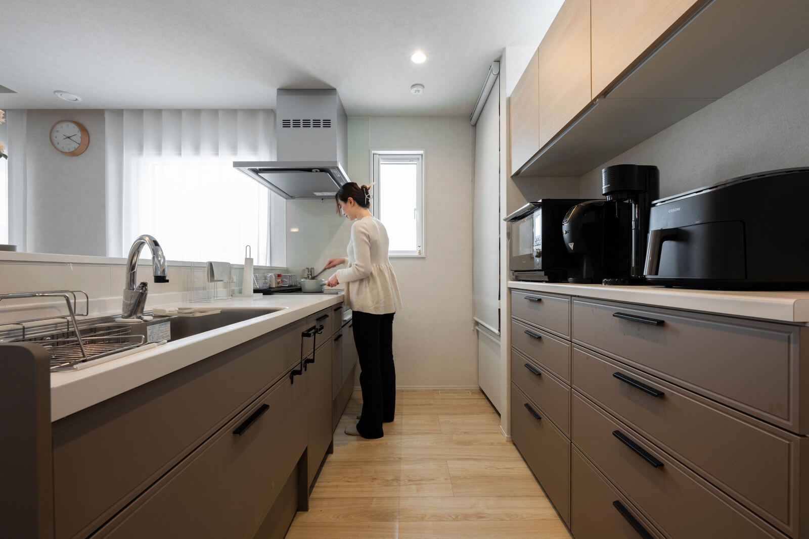 長時間作業をしても腰が痛くならないよう考慮し、通常より5c㎝高い90㎝にしたキッチン。南向きのLDKと吊り戸棚にある西向きのハイサイドライトから自然光が入り明るい