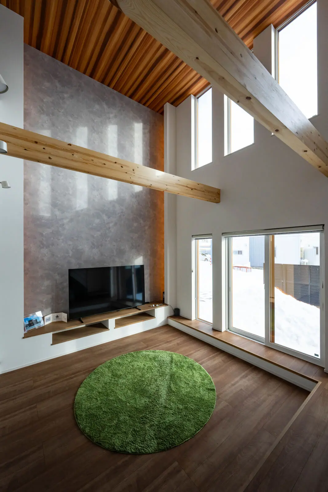 木目やコンクリート調の壁紙で個性的なテイストを加えたリビング。開口部には高性能なトリプルガラスを使用しているのでコールドドラフトが極めて少ない