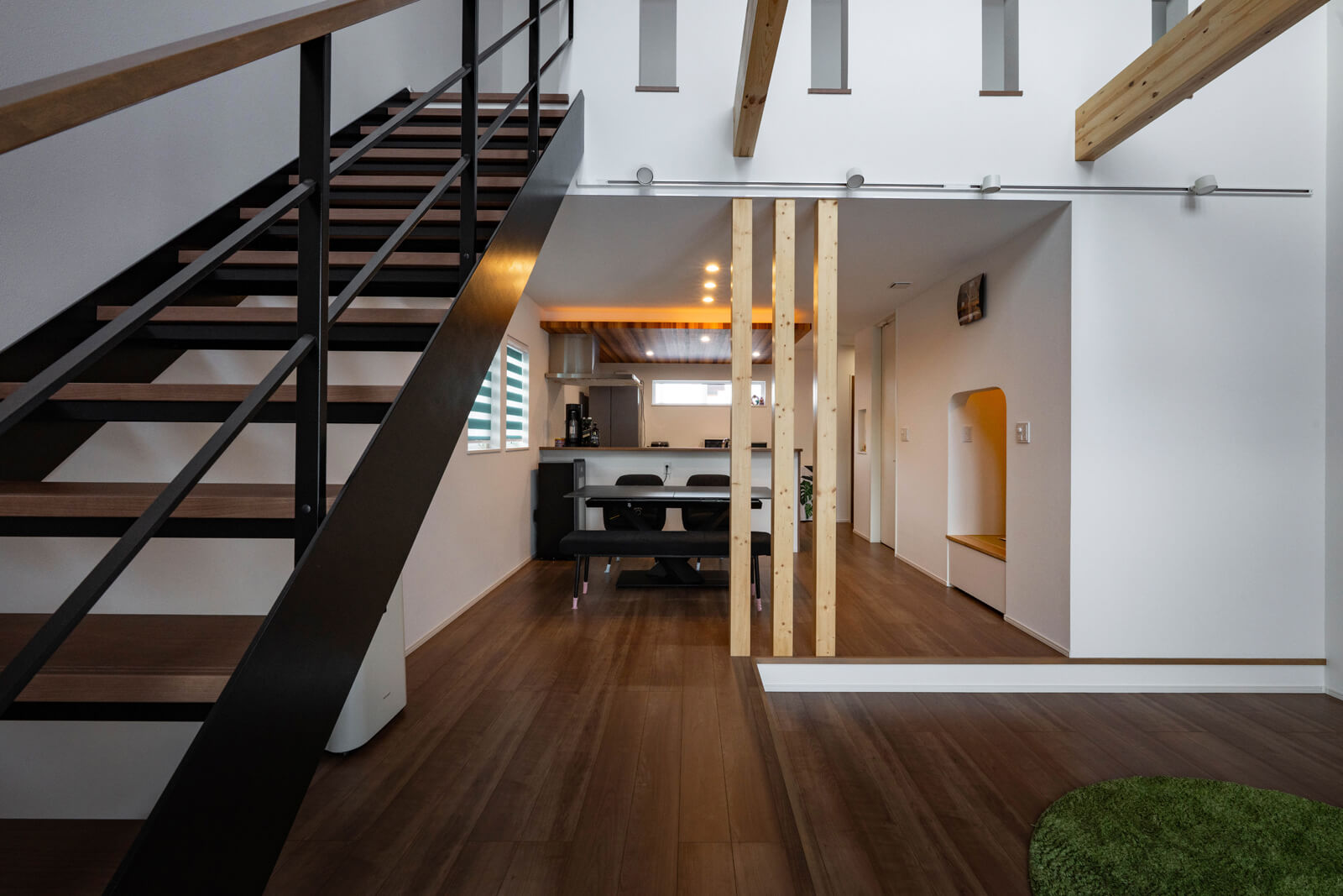 LDKはダウンフロアを含め23帖と広々。構造上必要な梁や柱と化粧柱を組み合わせて、デザインのアクセントにしている。黒に塗装した鉄骨階段で無骨さを演出した。頑丈なつくりなので上り下りの際に揺れを感じず安心