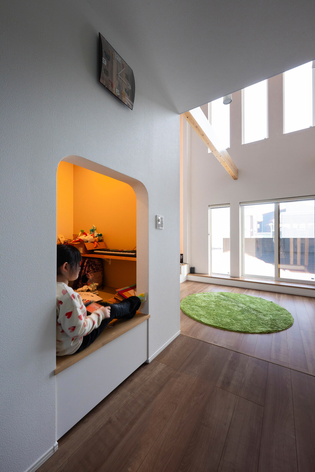 アールの下がり壁がかわいいヌック。1.5帖のこじんまりした広さと、屈まないと入れない入り口が秘密基地のような空間。小上がりになっていて、入り口部分と奥に収納スペースがある