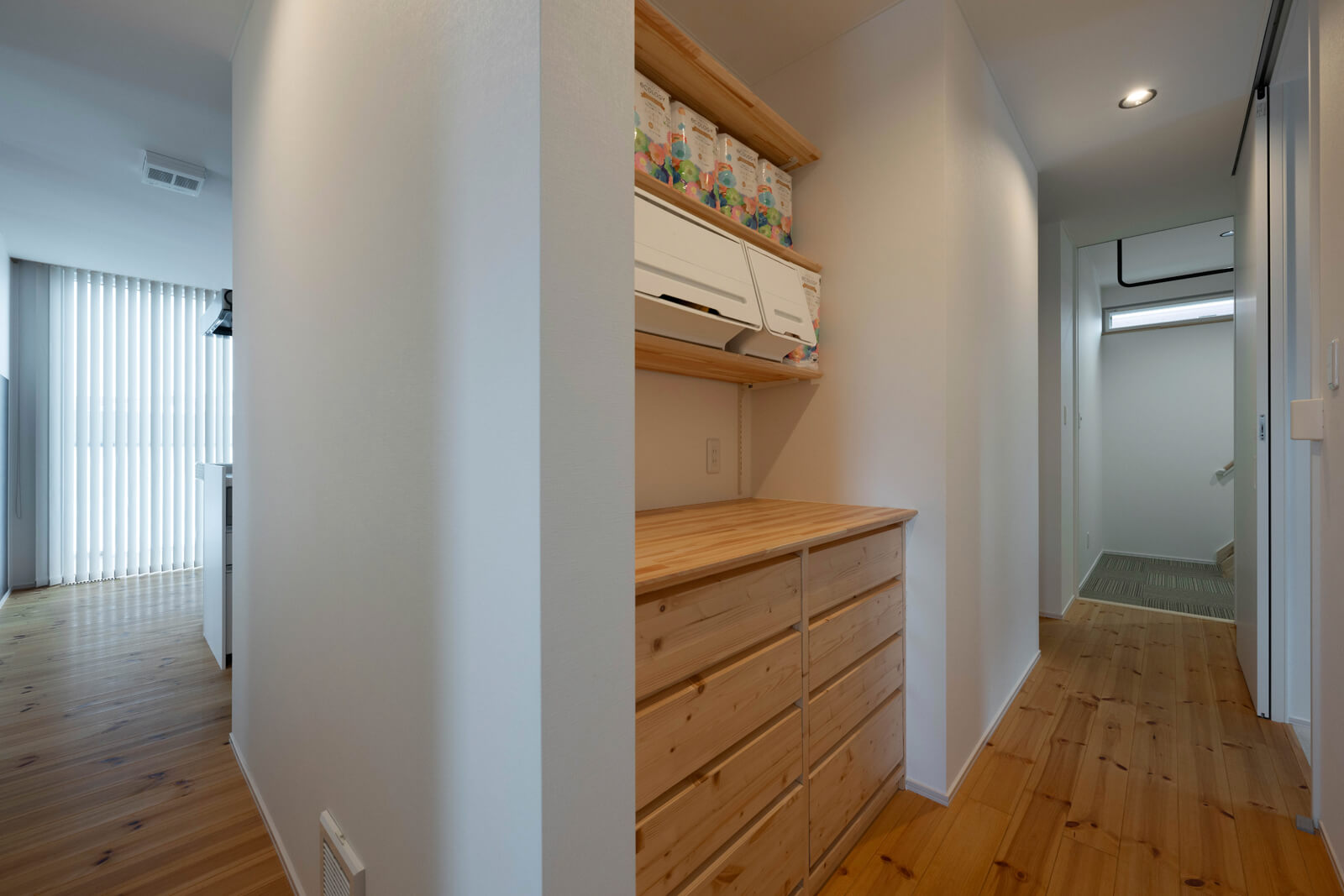 ゲストルームや水まわり、寝室が並ぶ裏動線上にも造作収納を設えた。写真左下に見えるのが全館空調の吸気口。吸引した空気がダクトで天井裏に送られ、天井の吸気口から送風される。快適な空気を室内中に隈なく行き渡らせるS-ONEハウス＋の工夫