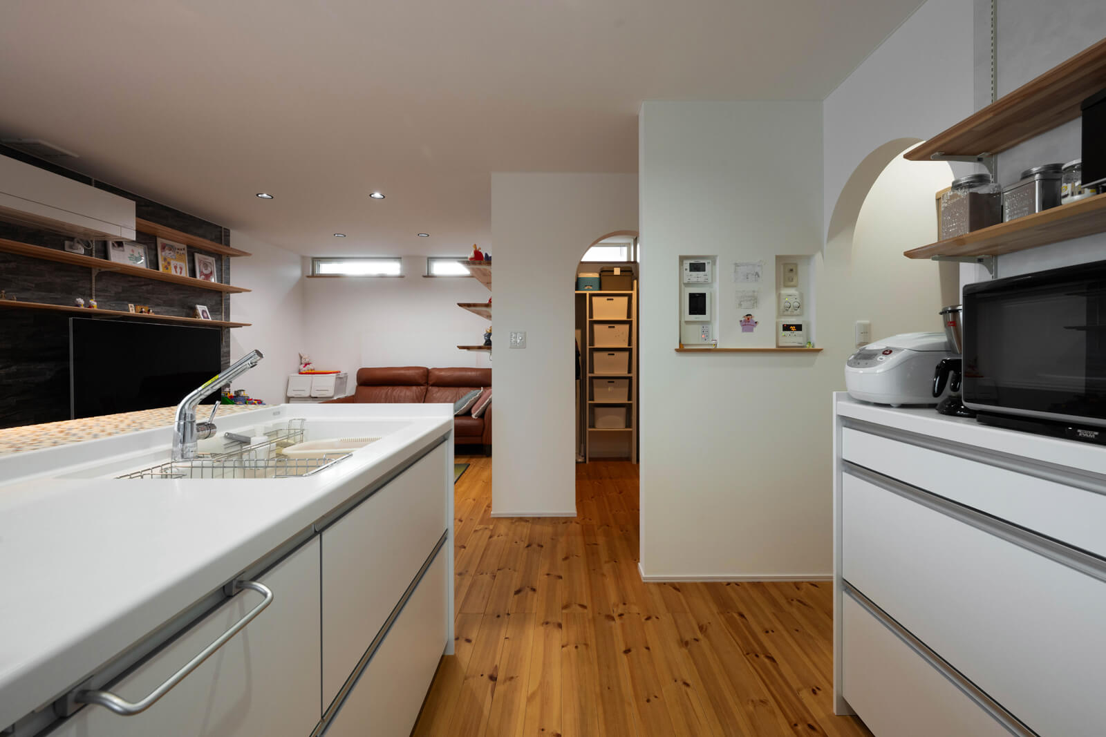 アイランドキッチンと背面の収納までは約1mあり、大人二人がすれ違っても余裕。キッチンの高さは通常85㎝だが、奥さんの身長に合わせて90㎝にした