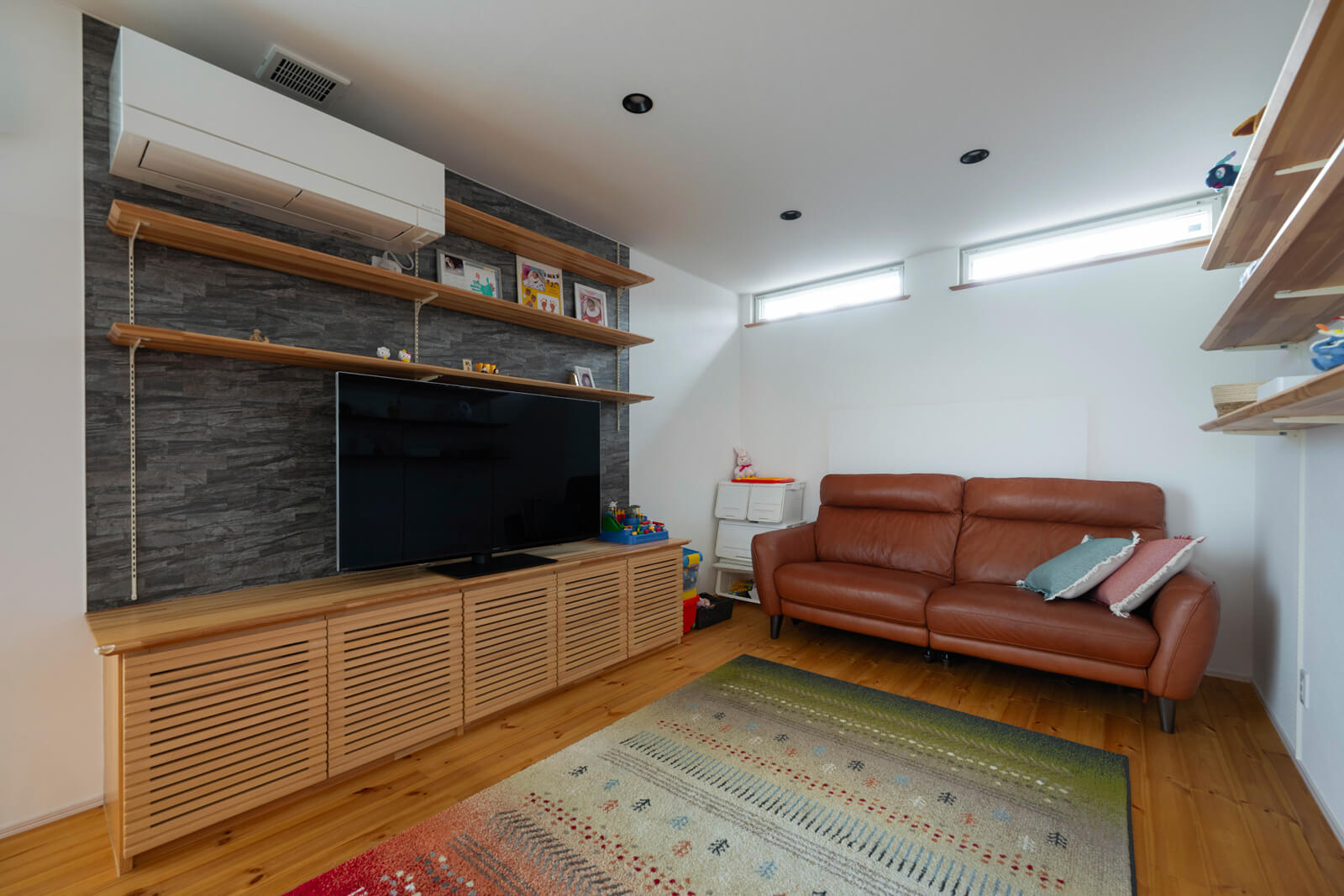 ファミリールームは約4.5帖。ハイサイドライトでプライバシーを保護しつつ、採光を確保している。造作テレビ台の中に床下温水ヒーターを収納している