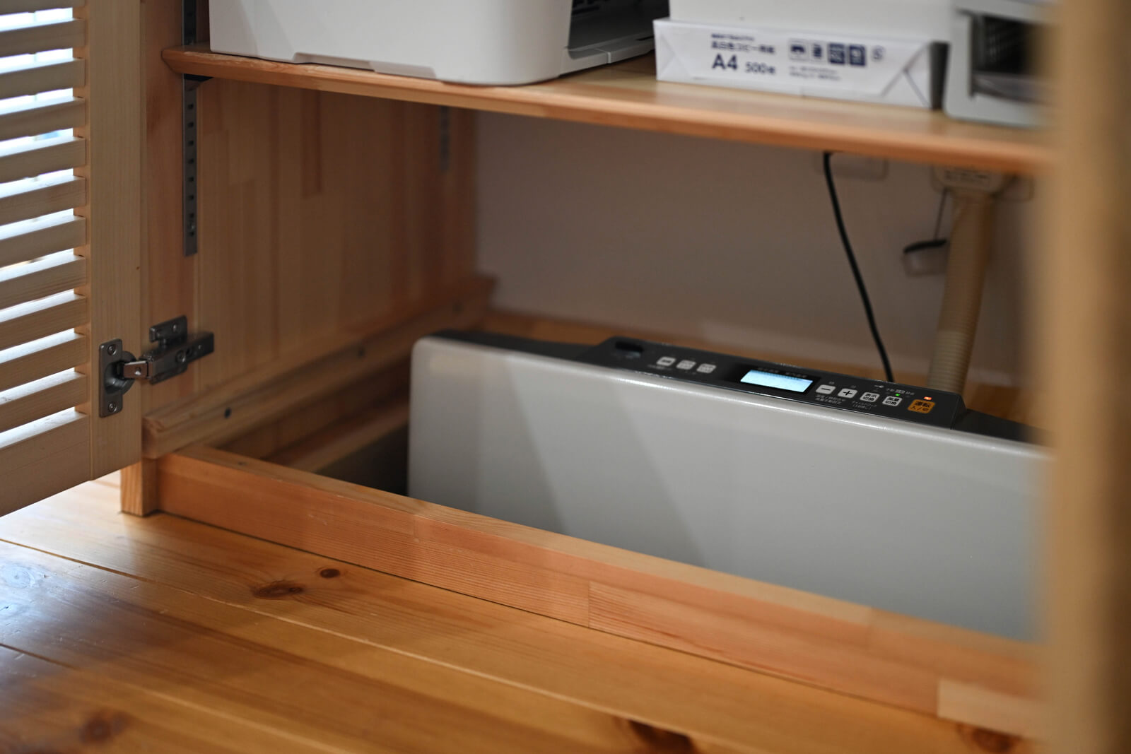 テレビ台に収納された床下温水ヒーター。パネル部分が床上に出ているので、温度調整は楽にできる