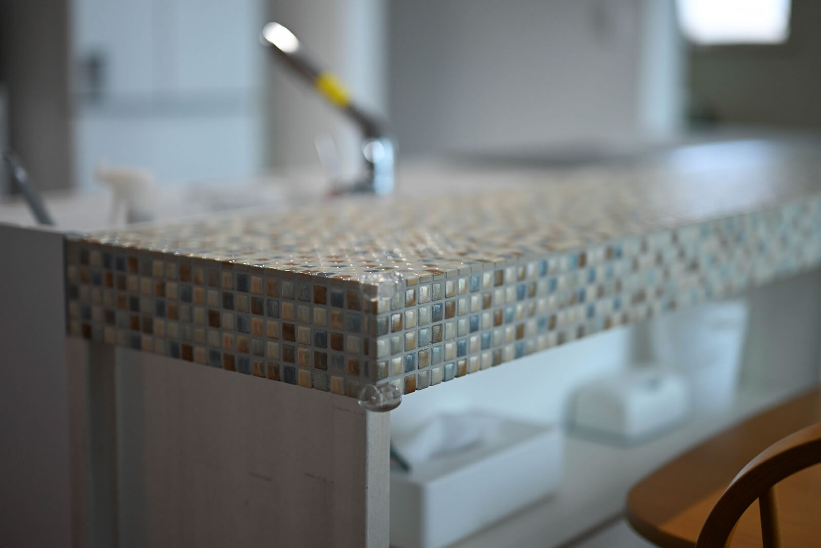 タイル張りのキッチンカウンター。さり気ない色合いでシンプルなデザインの室内に溶け込んでいる