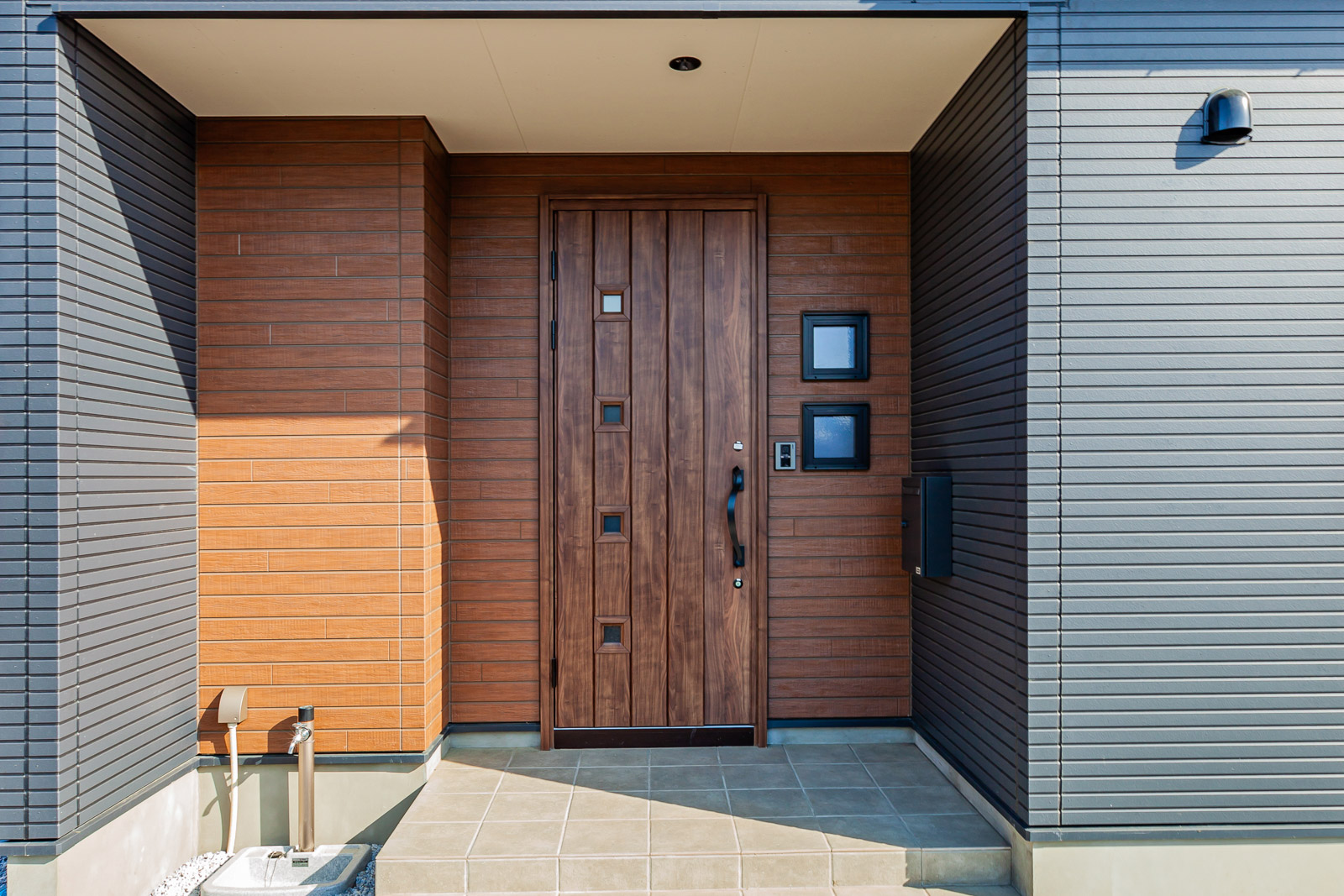 窯業系サイディングの外壁は玄関まわりを木目調にし、デザインのアクセントをつけた