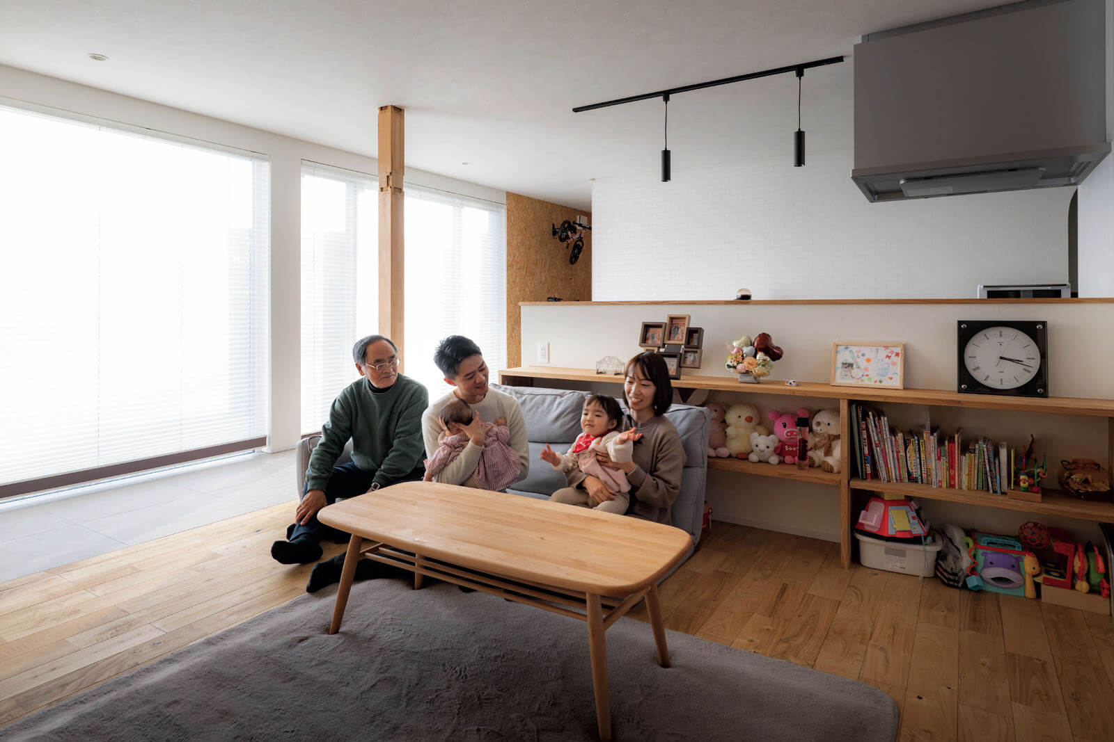 リビングでくつろぐTさんご家族。南面の大開口から射し込む陽の光に包まれ、穏やかな時間が流れる