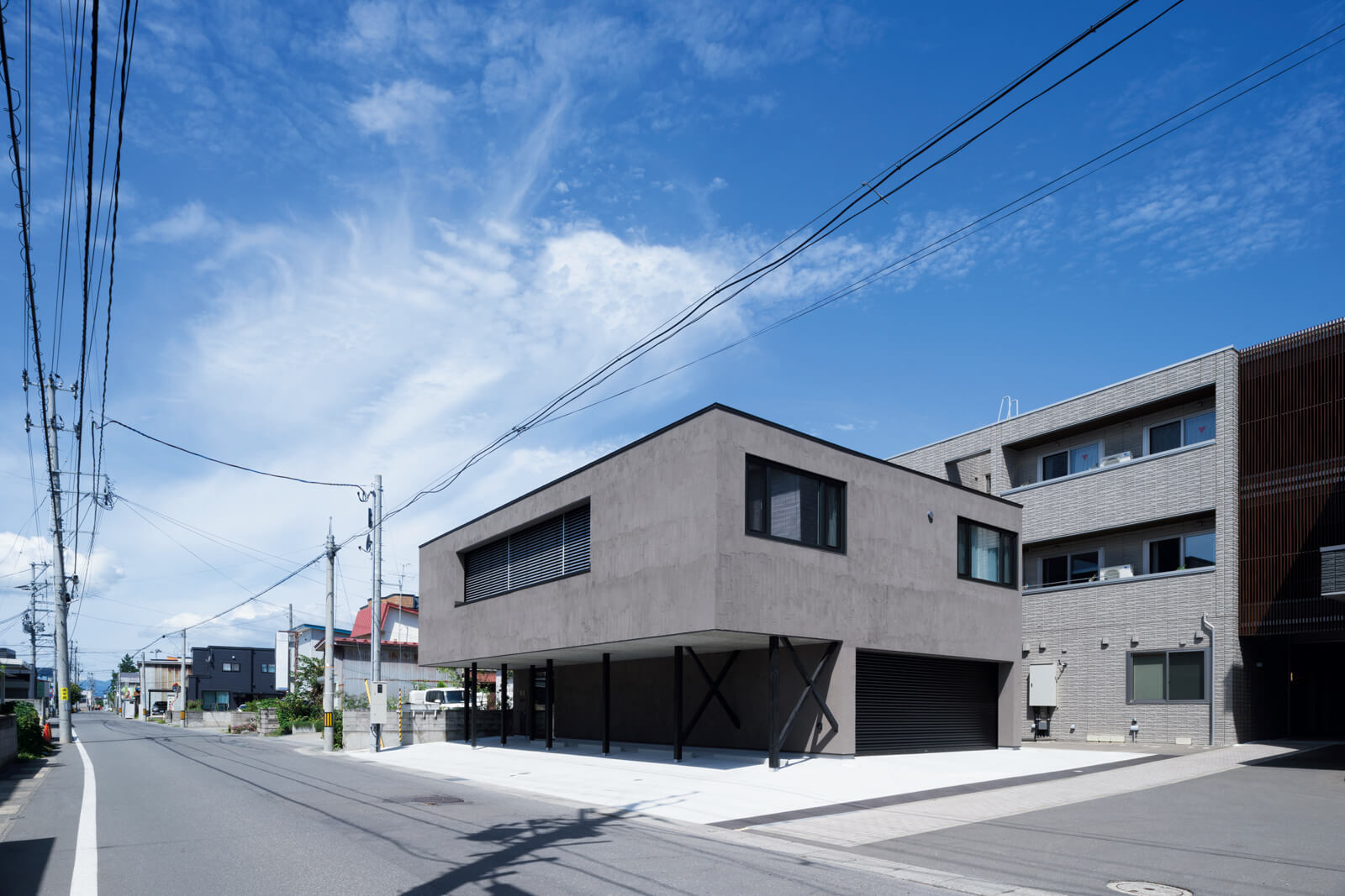 日中の外観。南側の窓には外付けブラインドを設置して、外部からの視線と直射日光を調整している