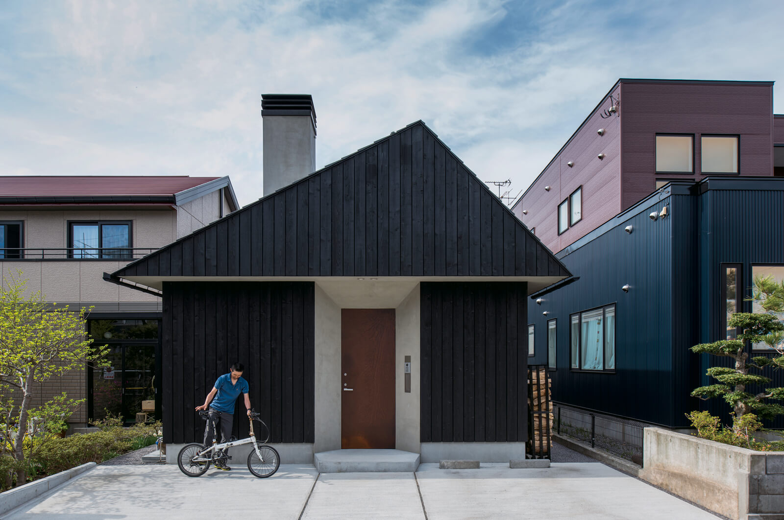 三角屋根で山小屋風の外観。玄関ドアはさび加工を施したアイアン張りの特注品