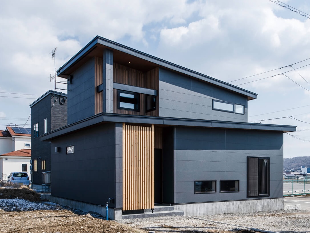 太陽光発電パネルを搭載したKさんご一家の住まい。落ち着いたブラックグレー調のサイディングがスタリッシュ